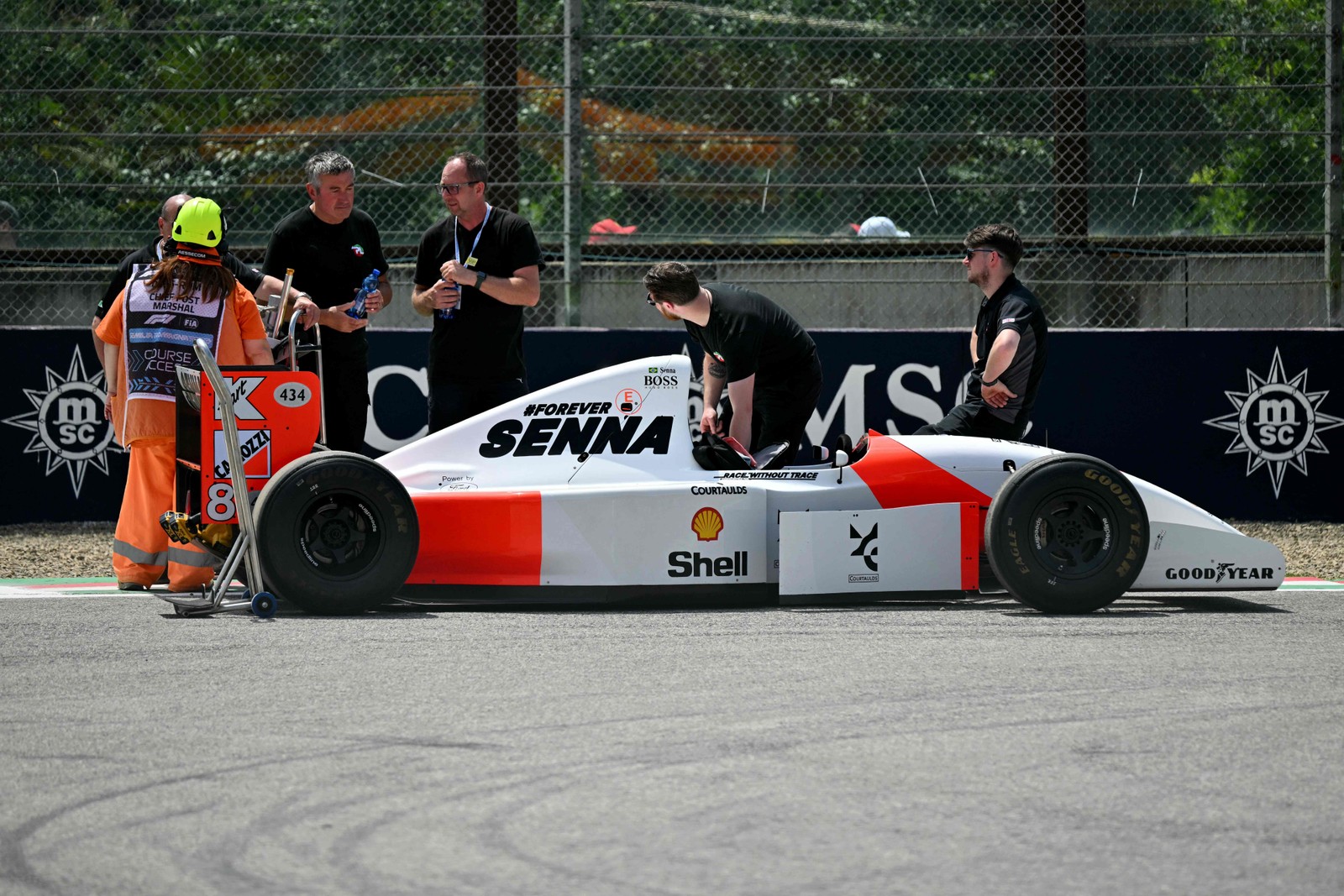 O histórico carro da McLaren do falecido piloto brasileiro Ayrton Senna é preparado para o desfile dos pilotos, para marcar o 30º aniversário de sua morte, antes do Grande Prêmio de Fórmula 1 da Emilia Romagna, no Autódromo Enzo e Dino Ferrari, em Ímola. — Foto: ANDREJ ISAKOVIC/AFP