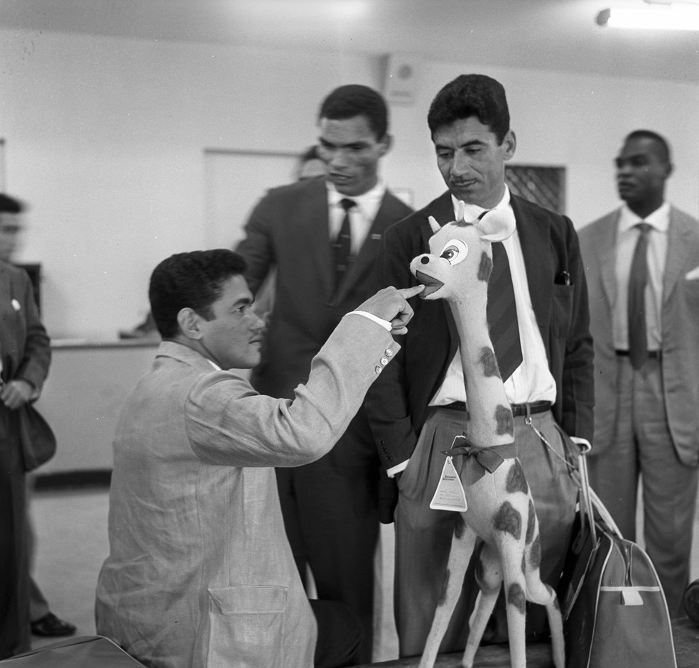 Girafa de pelúcia, Nilton Santos, Garrincha e Manga no Aeroporto do Galeão em 1961 — Foto: Arquivo / O Globo